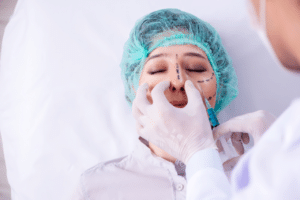 Un chirurgo che esegue delle punture sul viso di una donna