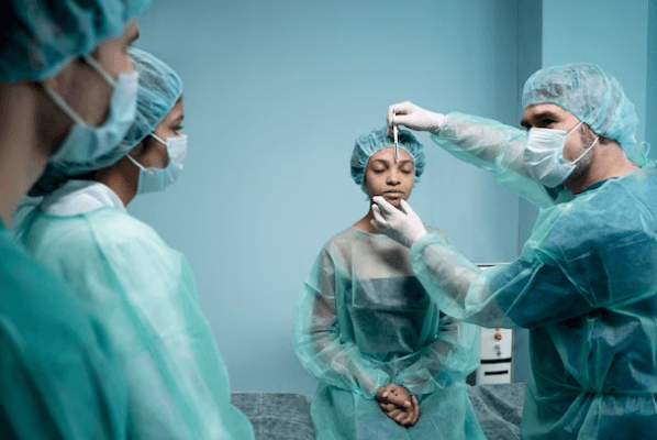 Un medico chirurgo che visita una sua paziente con il suo team prima dell'intervento